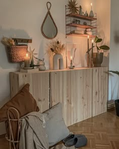 a living room filled with lots of furniture next to a wooden shelf covered in candles