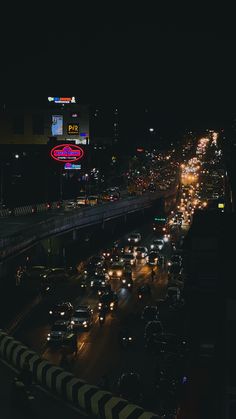 a busy city street filled with lots of traffic at night