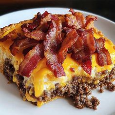 a slice of bacon and cheese quiche on a white plate with meat toppings