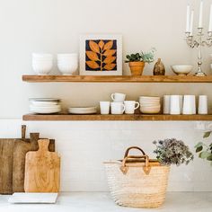 a kitchen shelf filled with plates, bowls and utensils on top of a counter