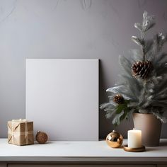 a table with a christmas tree, gift box and candle on it next to a blank canvas