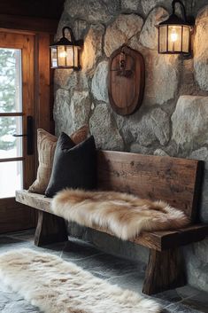 a wooden bench sitting in front of a stone wall with two lights on each side