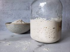 a glass jar filled with flour next to a bowl