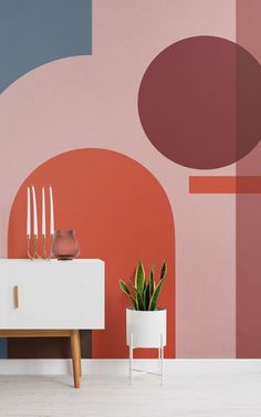 a living room with pink, blue and orange wallpaper on the walls next to a white table