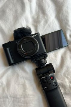 a camera attached to a tripod sitting on top of a bed