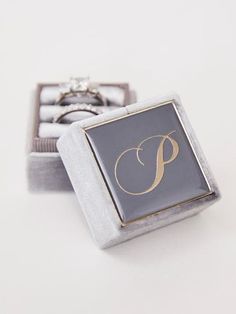 a ring with the letter p on it sitting in a box