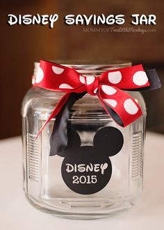 there is a glass jar with a minnie mouse on it and a red bow around the top