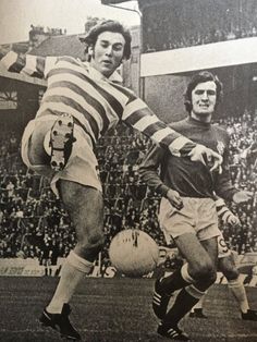 two men are playing soccer in an old photo