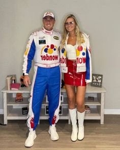 the man and woman are dressed up as race cars driver, with their arms around each other