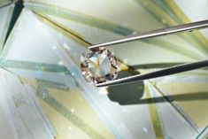 a diamond sitting on top of a pair of tongs