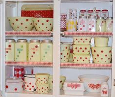 an open refrigerator filled with lots of dishes and cups in it's door shelves