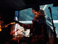 two people are playing guitars on stage