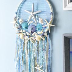 a blue wall hanging with shells, starfish and seashells attached to it