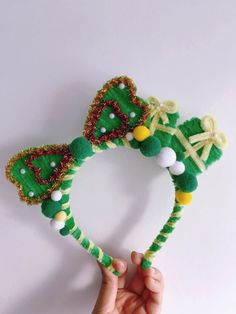 a hand holding up a green and yellow headband