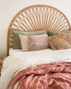 a bed with pillows and blankets on top of it next to a wall mounted clock