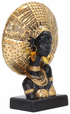 a gold and black statue of an african woman with large hoops on her head