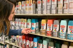 a woman is looking at the paint she has on her hand and pointing to it