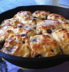 a casserole dish with cheese and blueberry toppings in a cast iron skillet