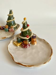 two ceramic christmas trees sitting on top of a plate