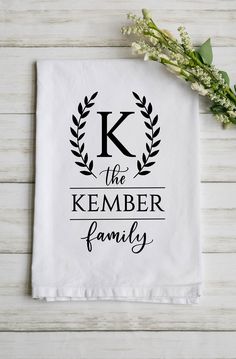 a white tea towel with the words k is the kember family printed on it