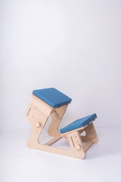 a wooden chair with blue cushion on it's seat and back rests against a white background