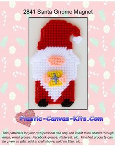 a crocheted santa clause ornament on a pink background