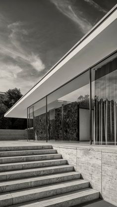 black and white photograph of stairs leading up to a building with glass doors on it