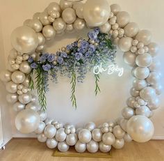 the balloon arch is decorated with flowers and balloons