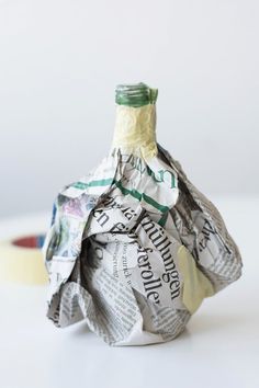 a bottle wrapped in newspaper sitting on top of a table