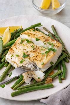 a white plate topped with fish and green beans