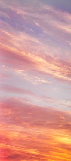 an airplane is flying in the sky at sunset or sunrise with pink and blue clouds