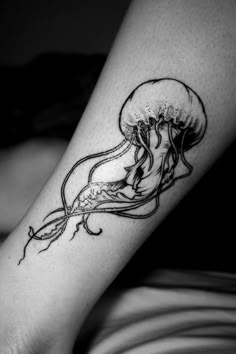 a woman's leg with a jellyfish tattoo on it