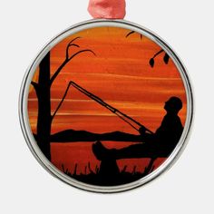 an ornament depicting a man fishing at sunset