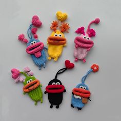 several crocheted toys are arranged in the shape of cartoon character heads and hands