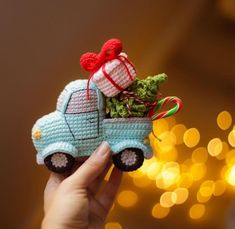 a small crocheted truck with a christmas tree in it's bed is being held by someone