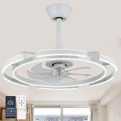 a ceiling fan with remote controls on it in a room next to a large window