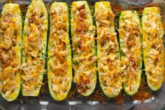 zucchini stuffed with cheese and other toppings in a baking dish on a table