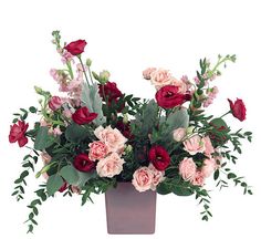 a vase filled with lots of pink and red flowers