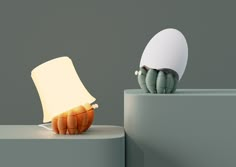 an egg sitting on top of a table next to a piece of paper with a light in it