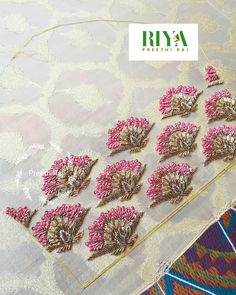 pink and gold broochies are sitting on a piece of fabric with the word riya written across it