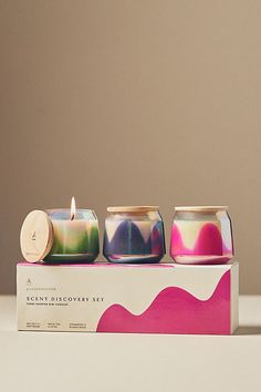 three colorful candles sitting on top of a box