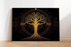 a black and gold tree of life poster on a wall in an empty room with wood flooring