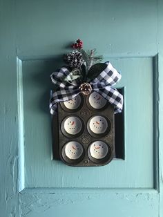 an egg carton with six eggs in it hanging on the front door, decorated with a bow