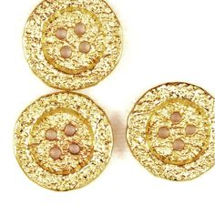 three gold colored buttons on a white background