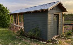 a small shed sitting in the middle of a field