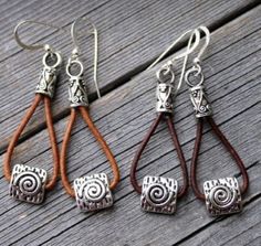 four pairs of earrings sitting on top of a wooden table