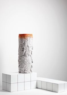 a tall vase sitting on top of a white block