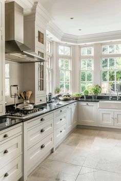 a large kitchen with white cabinets and black counter tops, along with an island in the middle