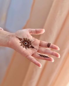 a woman's hand with henna tattoos on it