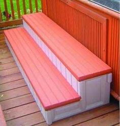 an orange and white bench sitting on top of a wooden deck next to a window